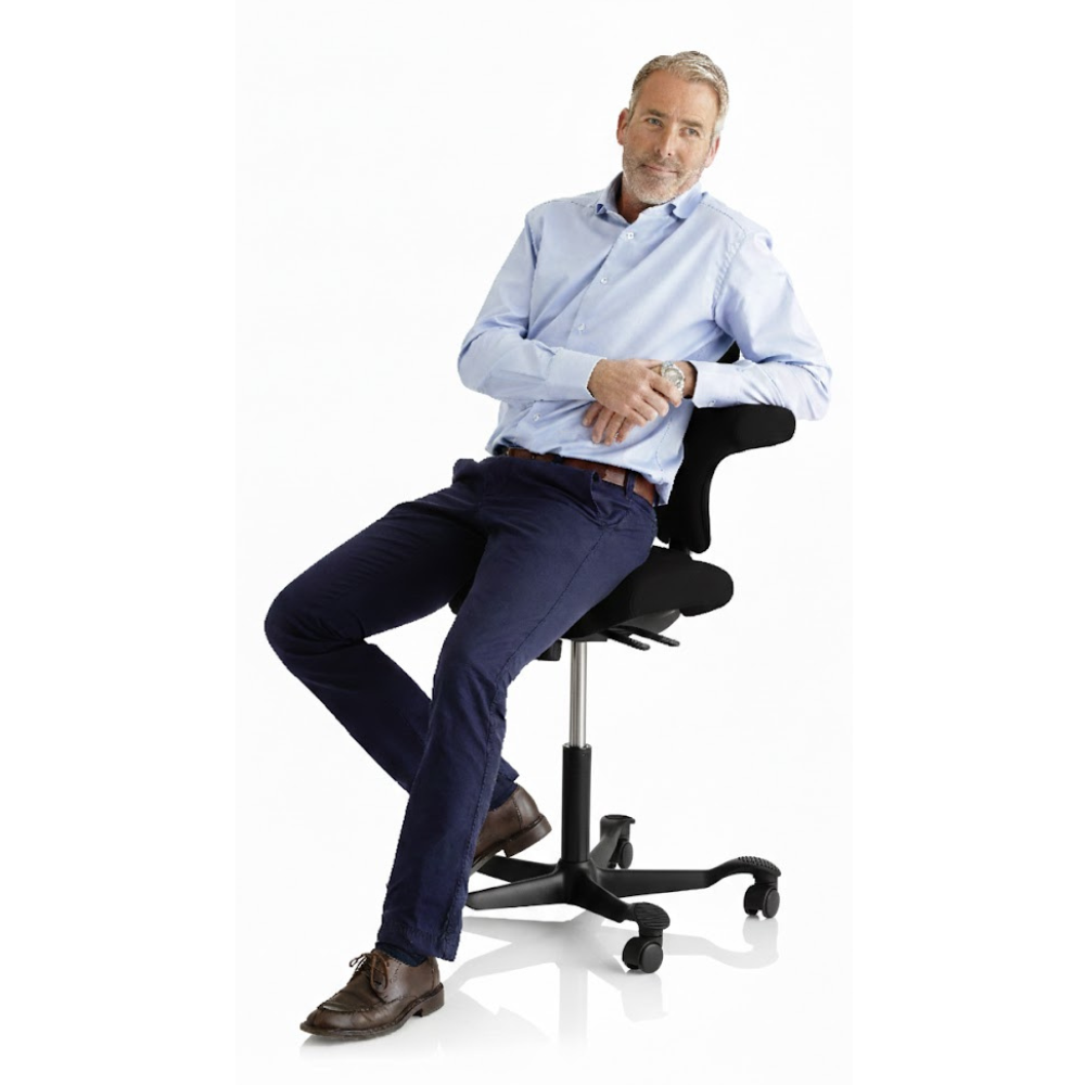 Persoon  leunend op de HÅG Capisco 8106 Ergonomische Bureaustoel – Zwart Frame