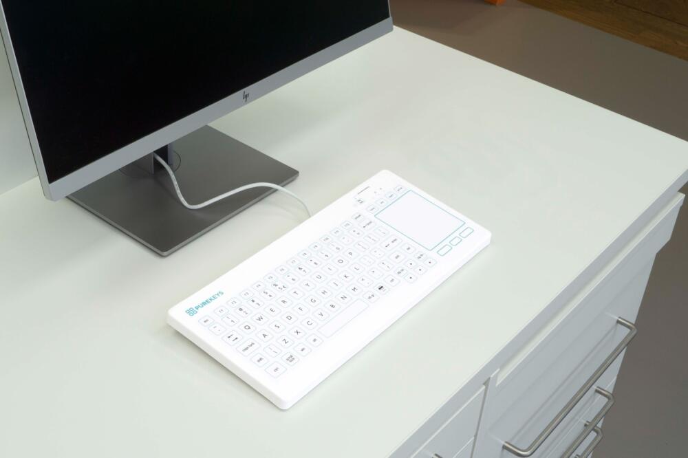 Het Purekeys medisch toetsenbord met touchpad US wit in een klinische setting, perfect voor hygiënisch werken.