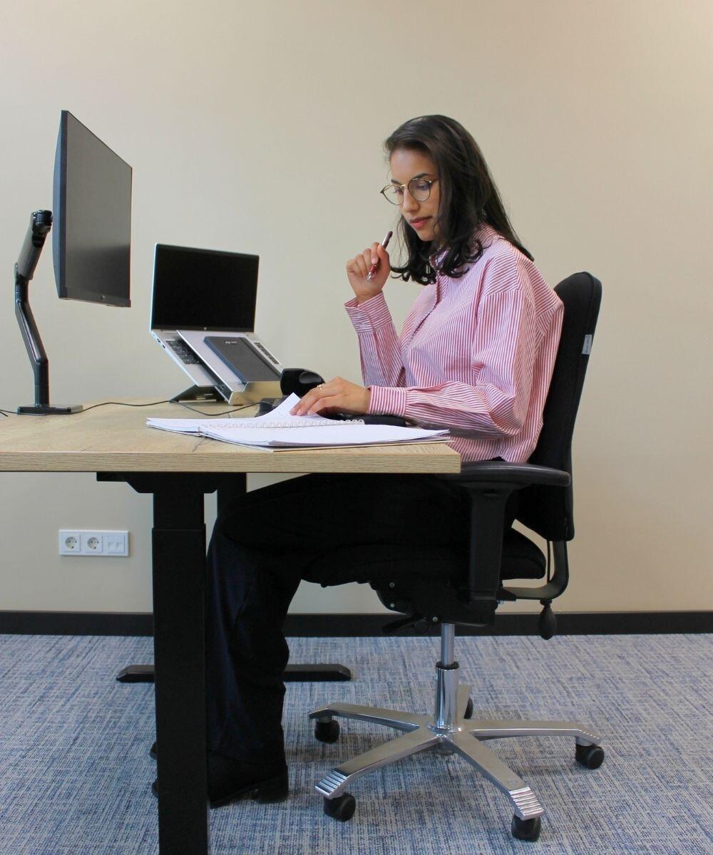 persoon aan het werk op de Score 5100 ergonomische bureaustoel zwart