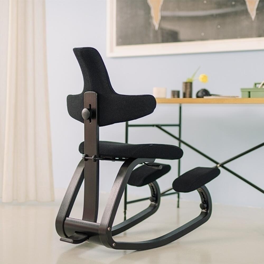 Variér Thatsit Balans Kniestoel met Rugleuning Zwart achter bureau