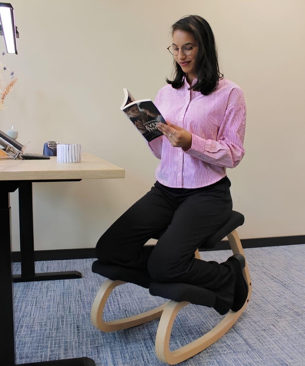 Boek aan het lezen op de Variér Variable Kniestoel Zonder Rugleuning Naturel Zwart