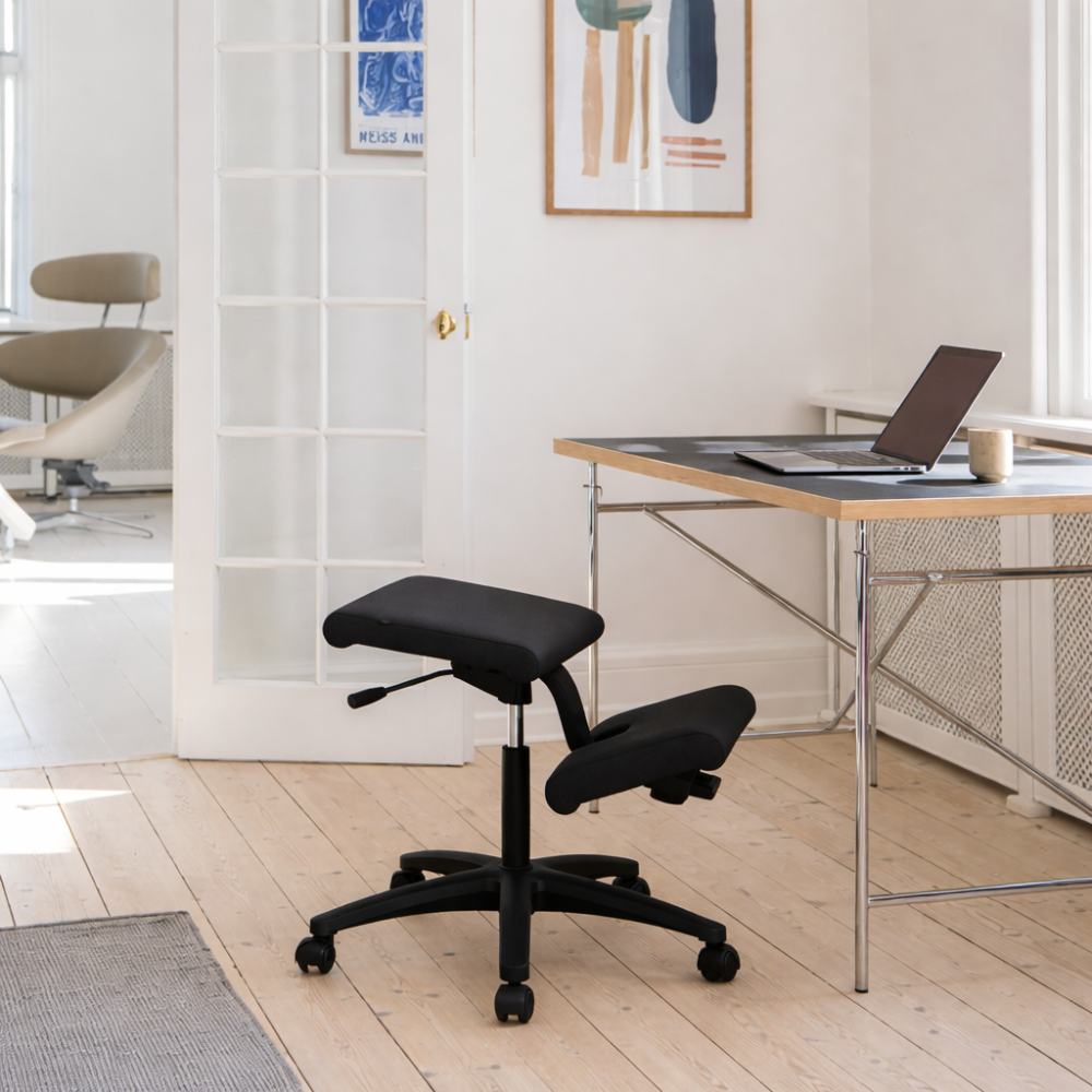 Variér Wing Balans Kniestoel met Wielen Zwart achter het bureau