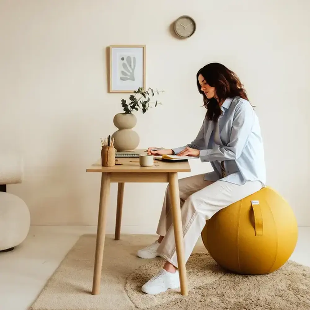 persoon aan het werk op de Vluv BOL LEIV Zitbal 60 65 cm Mustard